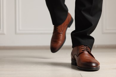 Photo of Businessman in elegant leather shoes indoors, closeup. Space for text