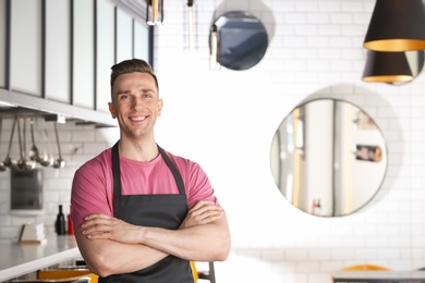 Photo of Portrait of young waiter in uniform at cafe