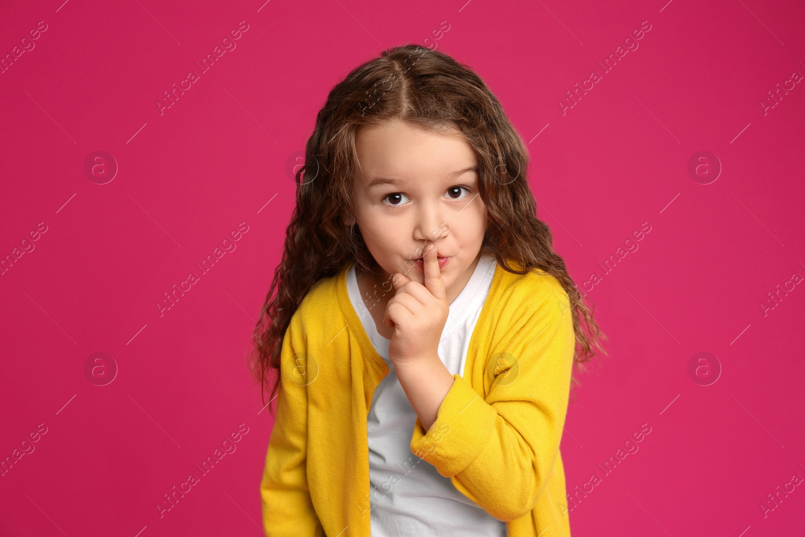 Photo of Portrait of cute little girl on pink background