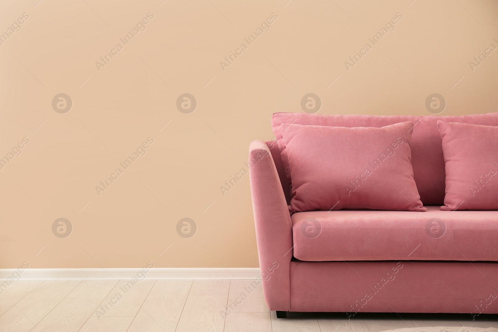 Photo of Simple living room interior with modern sofa near color wall. Space for text