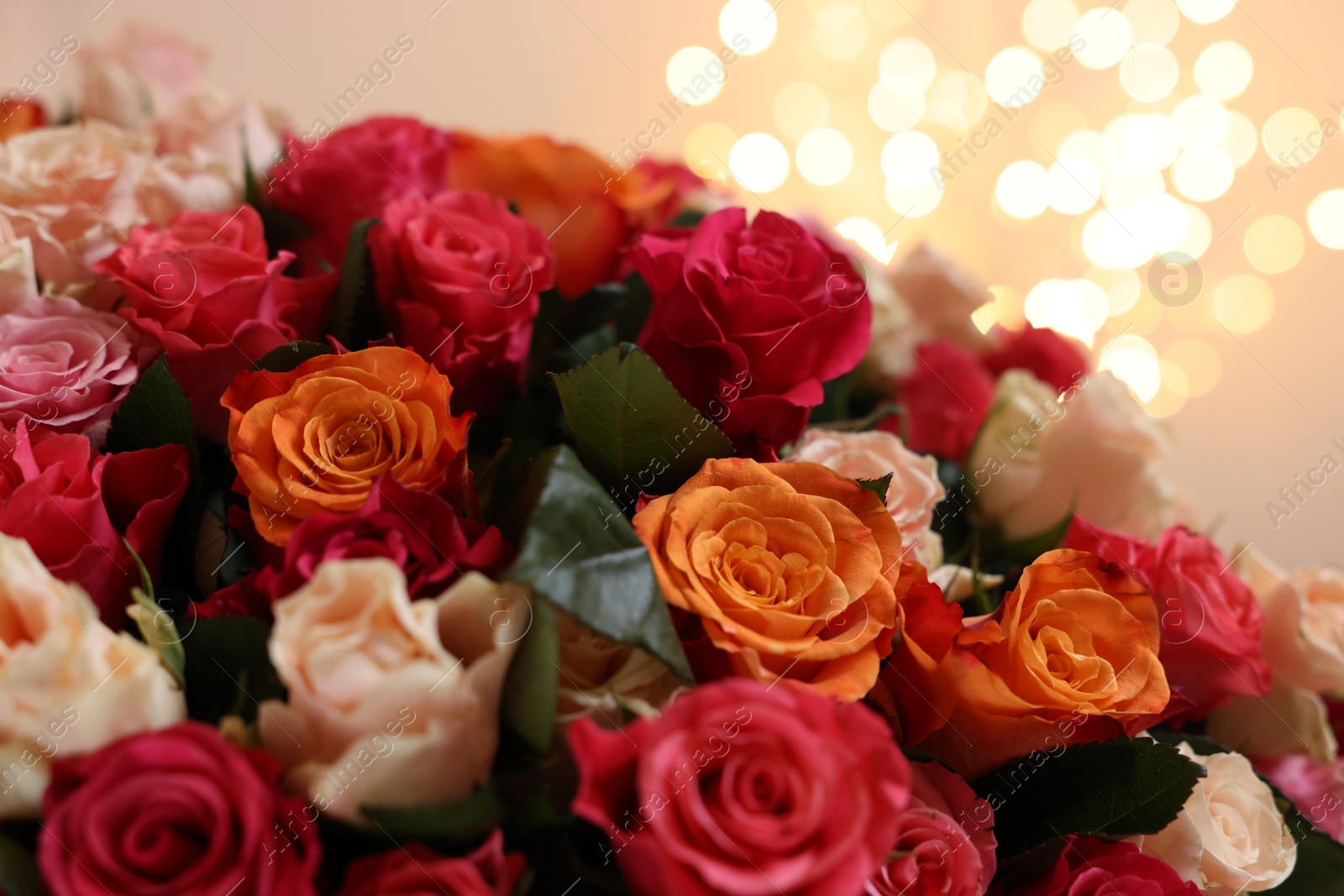 Photo of Beautiful bouquet of colorful roses on beige background, closeup