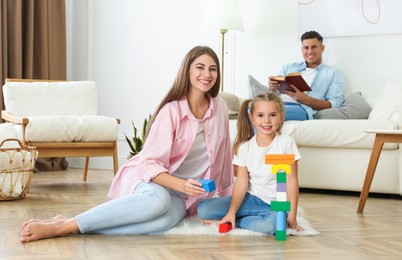 Photo of Mother playing with her daughter at home. Floor heating concept