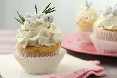 Photo of Tasty Easter cupcakes with vanilla cream on table