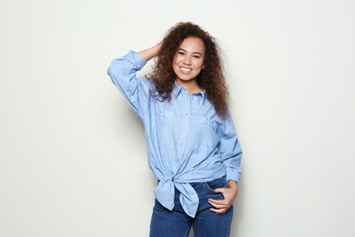 Photo of Young African-American woman with beautiful face on light background