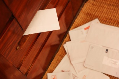 Photo of Mail slot with envelope in wooden door indoors, above view. Space for text