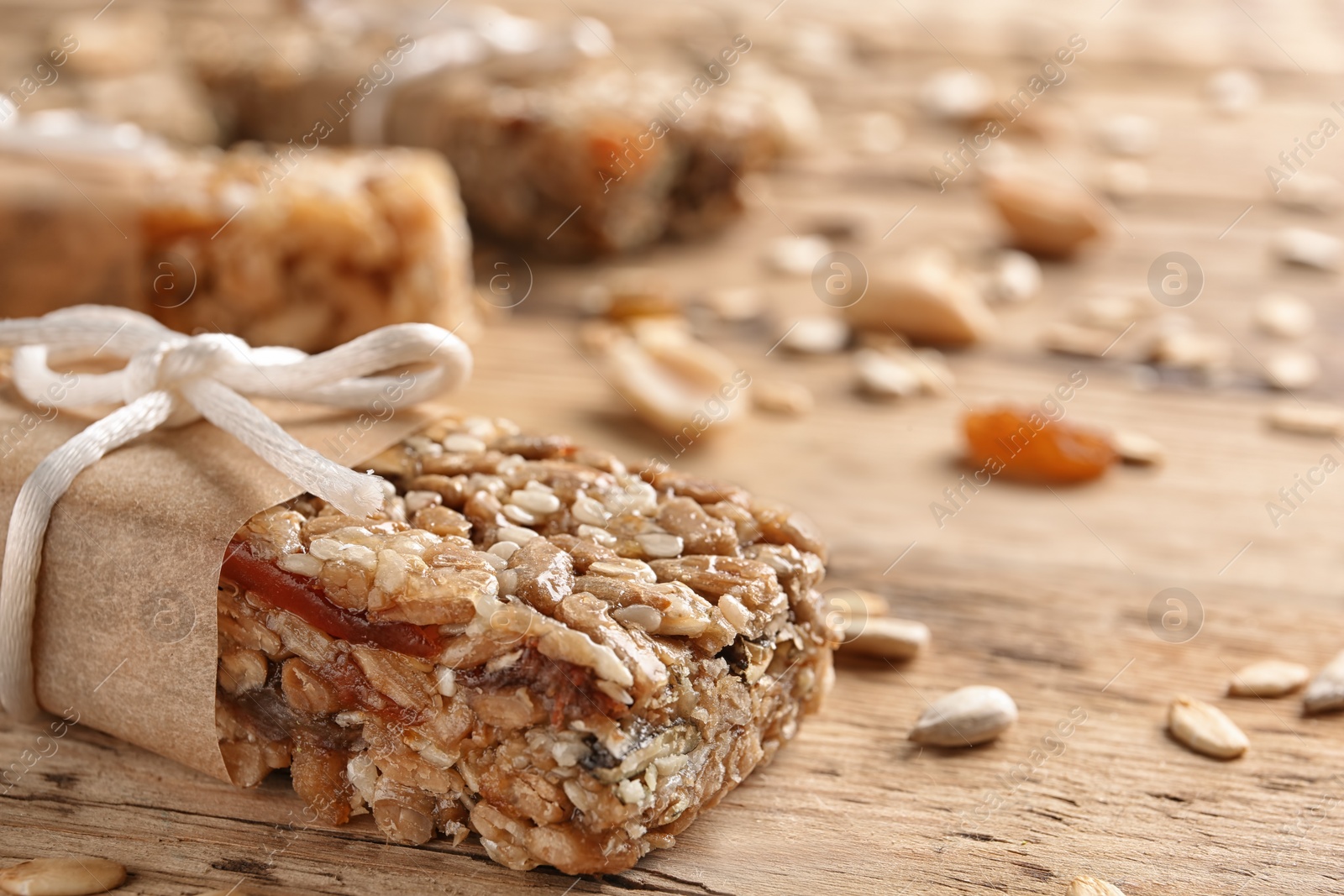 Photo of Homemade grain cereal bar on wooden table, closeup. Healthy snack