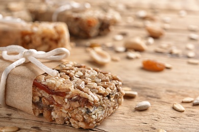 Photo of Homemade grain cereal bar on wooden table, closeup. Healthy snack