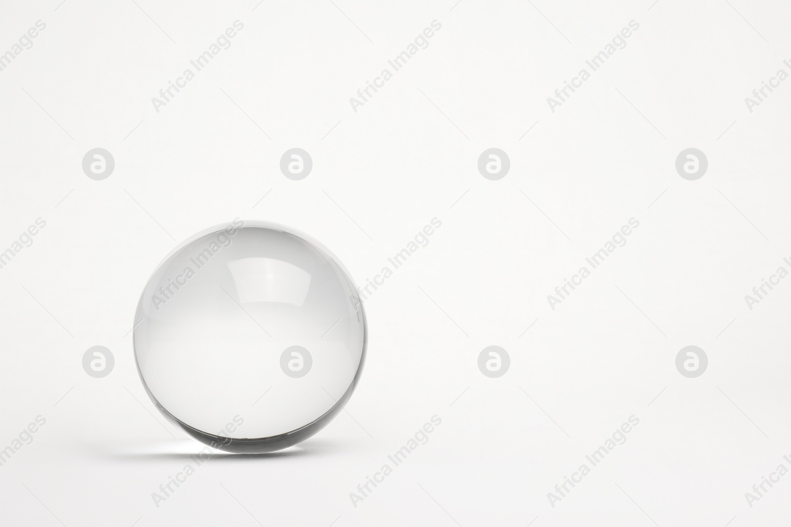 Photo of Transparent glass ball on white background. Space for text