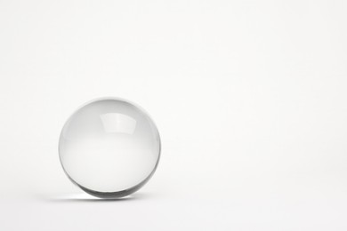 Transparent glass ball on white background. Space for text