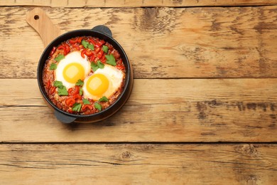 Delicious Shakshuka on wooden table, top view. Space for text