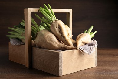 Basket with fresh sugar beets on wooden table