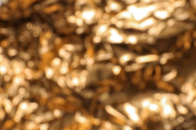 Photo of Blurred view of crumpled golden foil as background