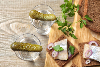 Photo of Cold Russian vodka with pickles on table, flat lay