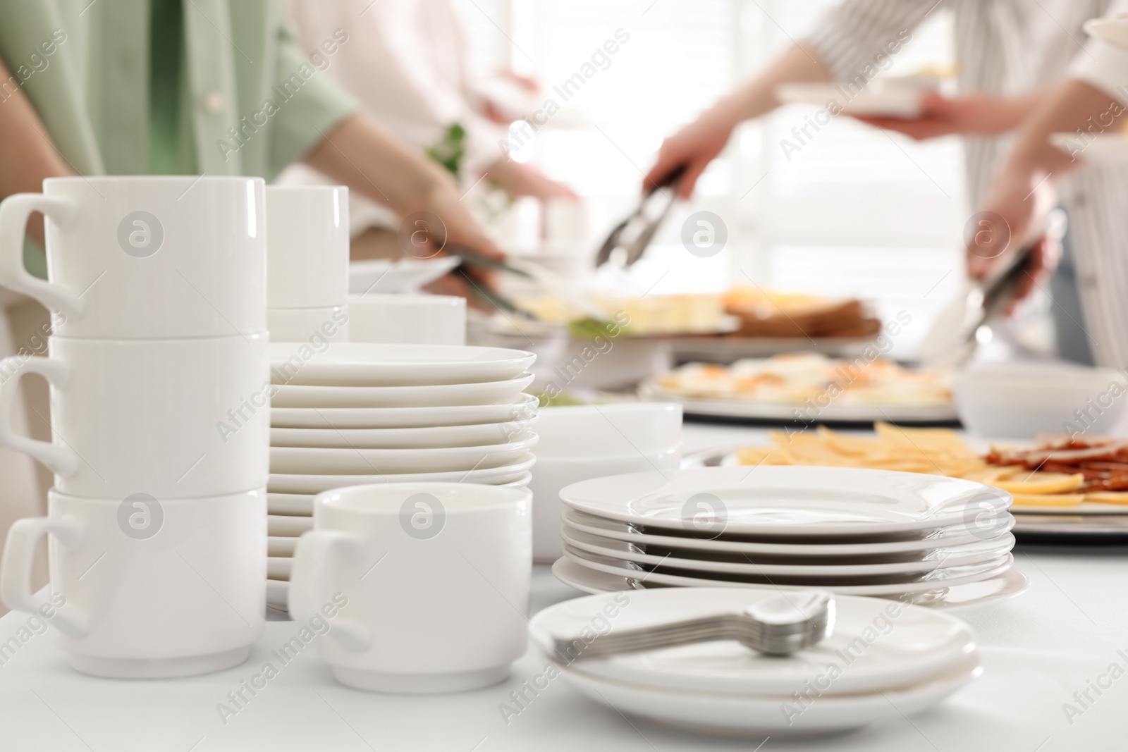 Photo of People taking food during breakfast, focus on clean dishware. Buffet service