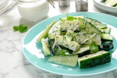 Photo of Plate with delicious cucumber salad on marble table, closeup