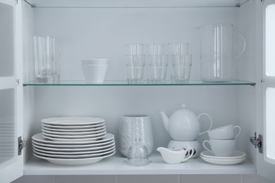 Photo of Cabinet with crockery and glassware. Order in kitchen