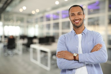 Portrait of handsome confident man in office, space for text