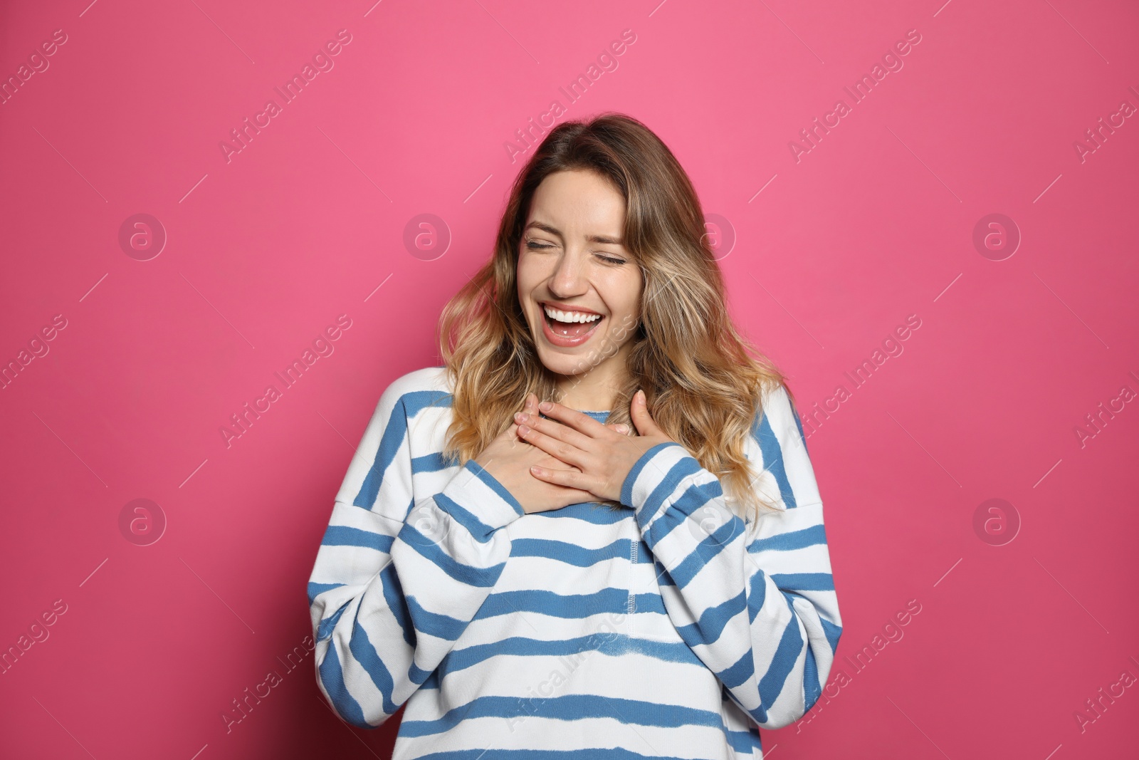 Photo of Cheerful young woman laughing on pink background