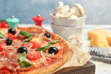 Delicious pizza with tomatoes and meat on table, closeup