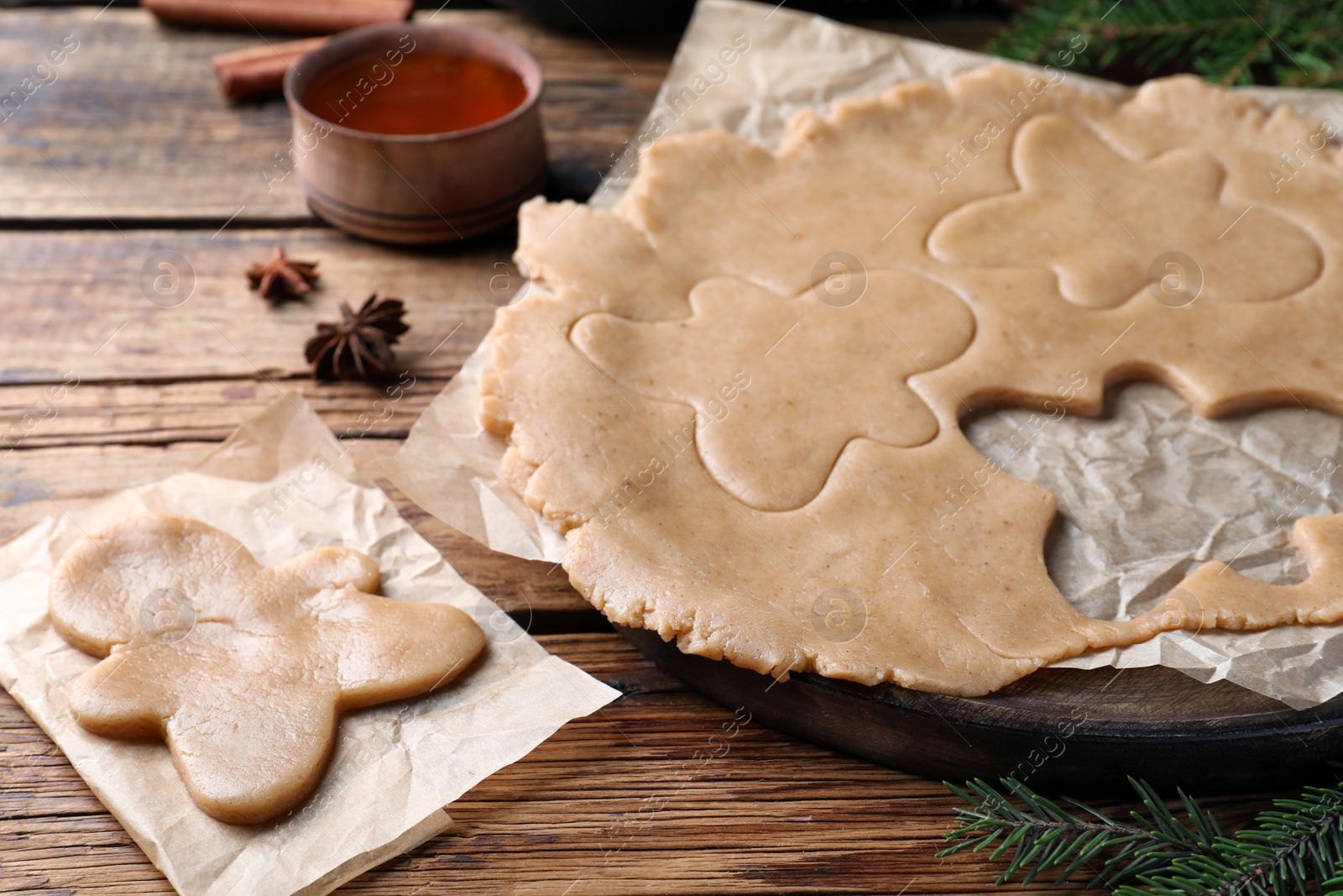 Photo of Making homemade Christmas cookies. Dough for gingerbread man on wooden table, closeup