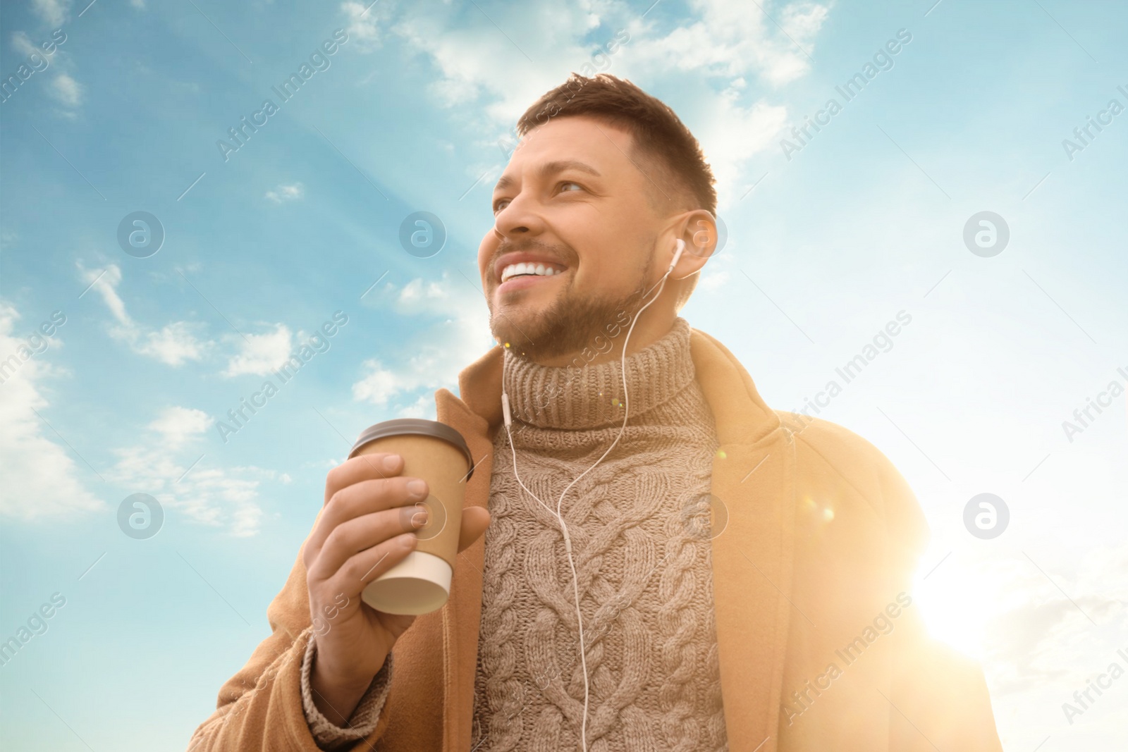 Photo of Man with cup of coffee on city street in morning