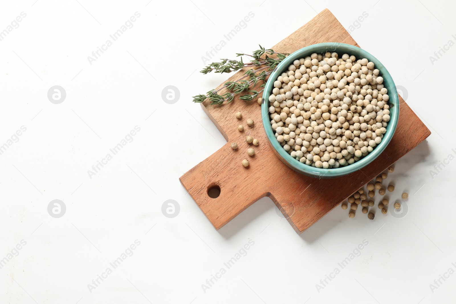 Photo of Aromatic spice. White pepper in bowl on white marble table, top view. Space for text