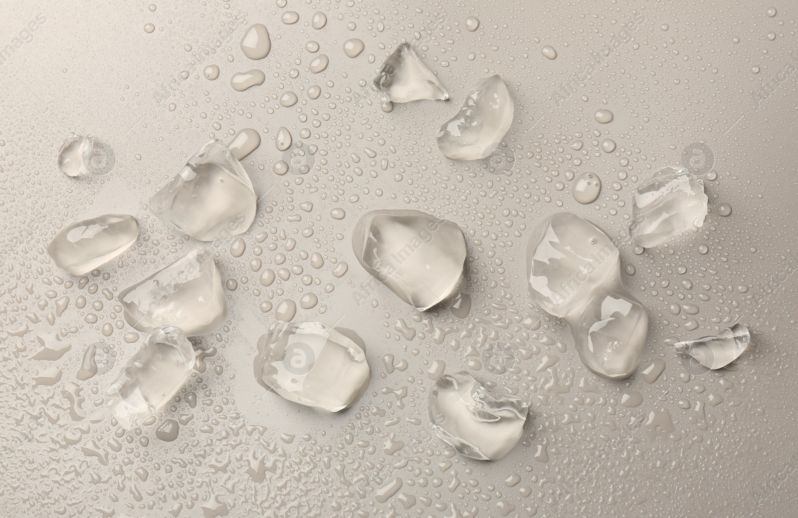 Photo of Pieces of crushed ice on grey background, top view