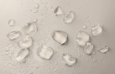 Pieces of crushed ice on grey background, top view