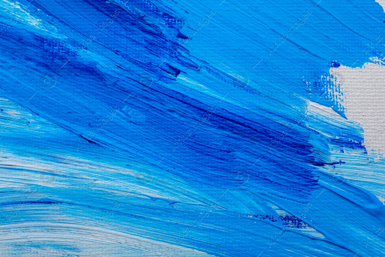 Photo of Beautiful strokes of blue oil paints on white canvas as background, closeup