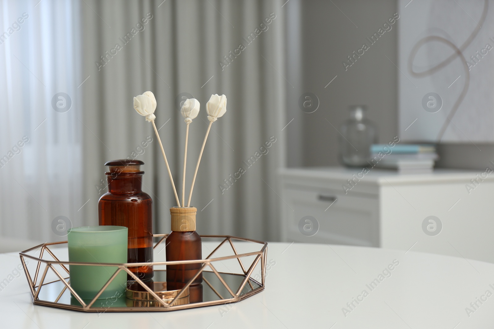 Photo of Air reed freshener and candle on white table in room, space for text