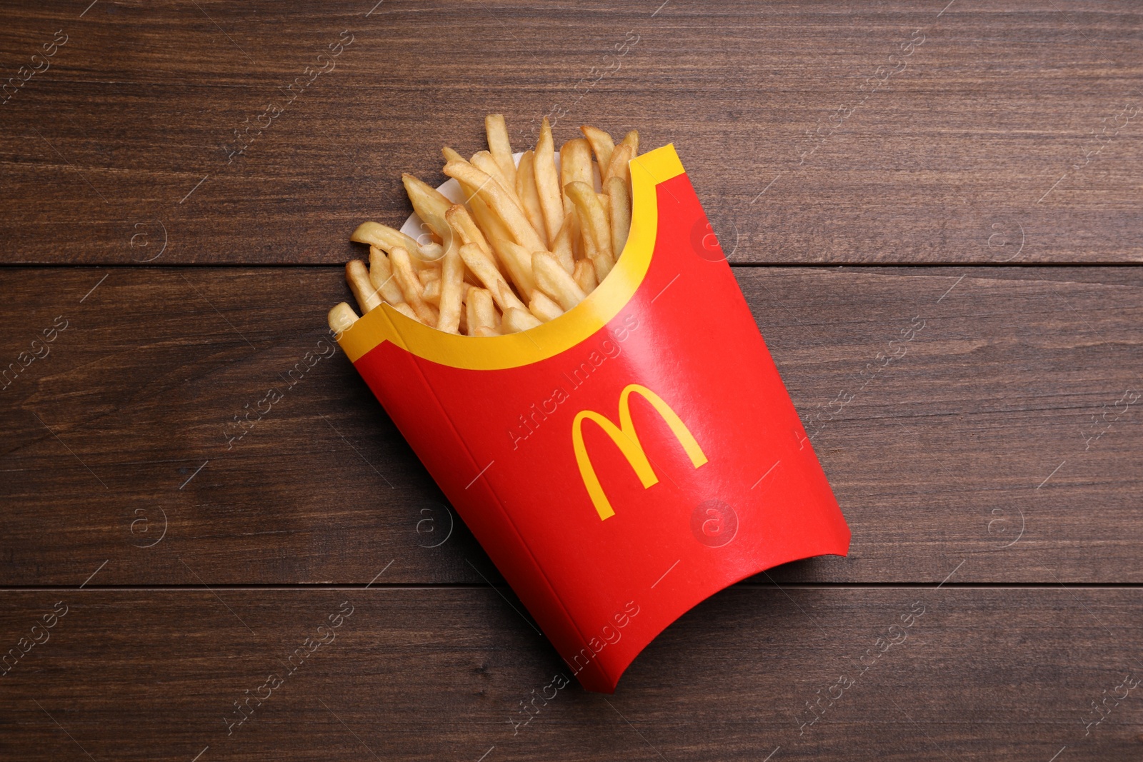 Photo of MYKOLAIV, UKRAINE - AUGUST 12, 2021: Big portion of McDonald's French fries on wooden table, top view