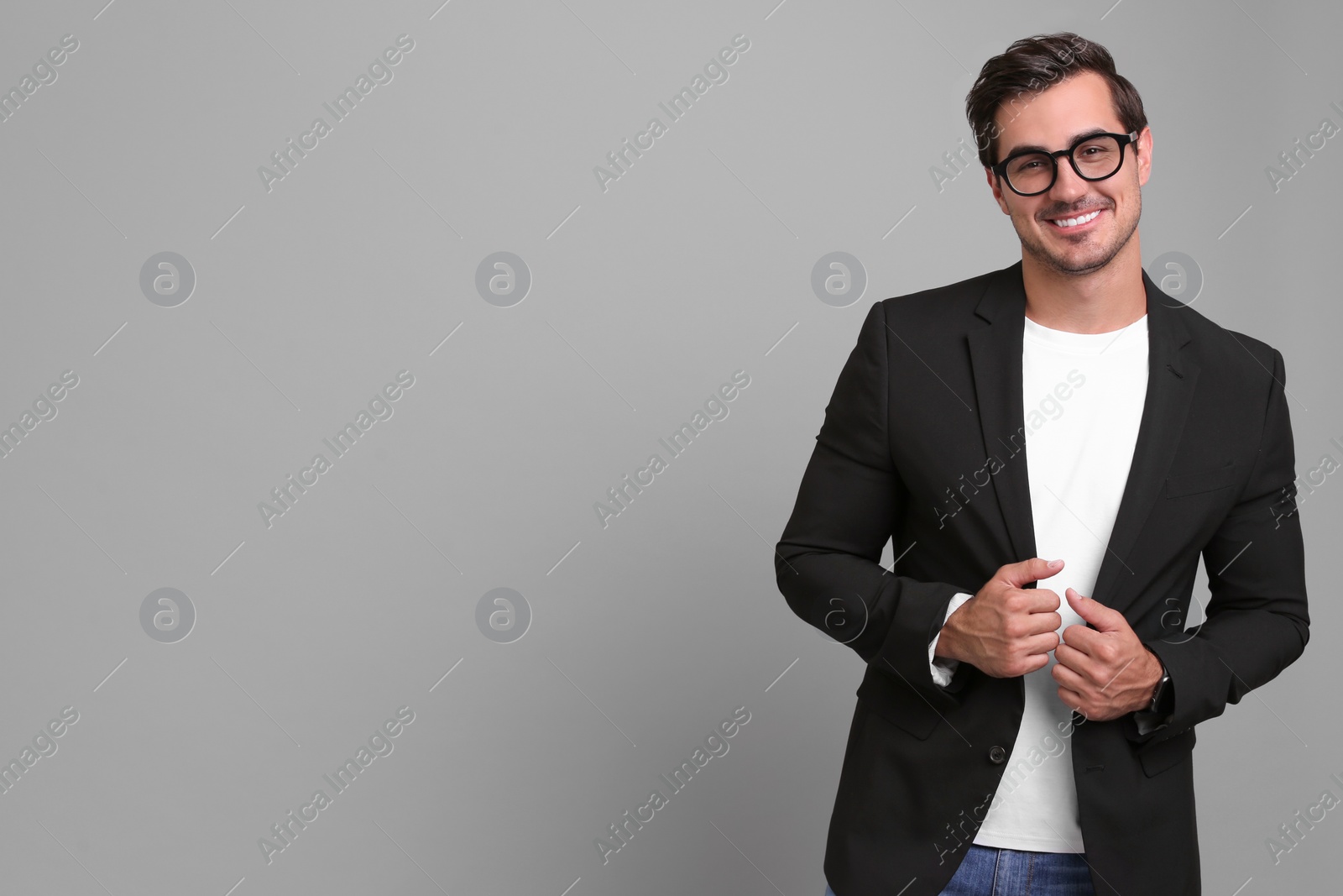 Photo of Handsome young man in casual clothes on grey background. Space for text