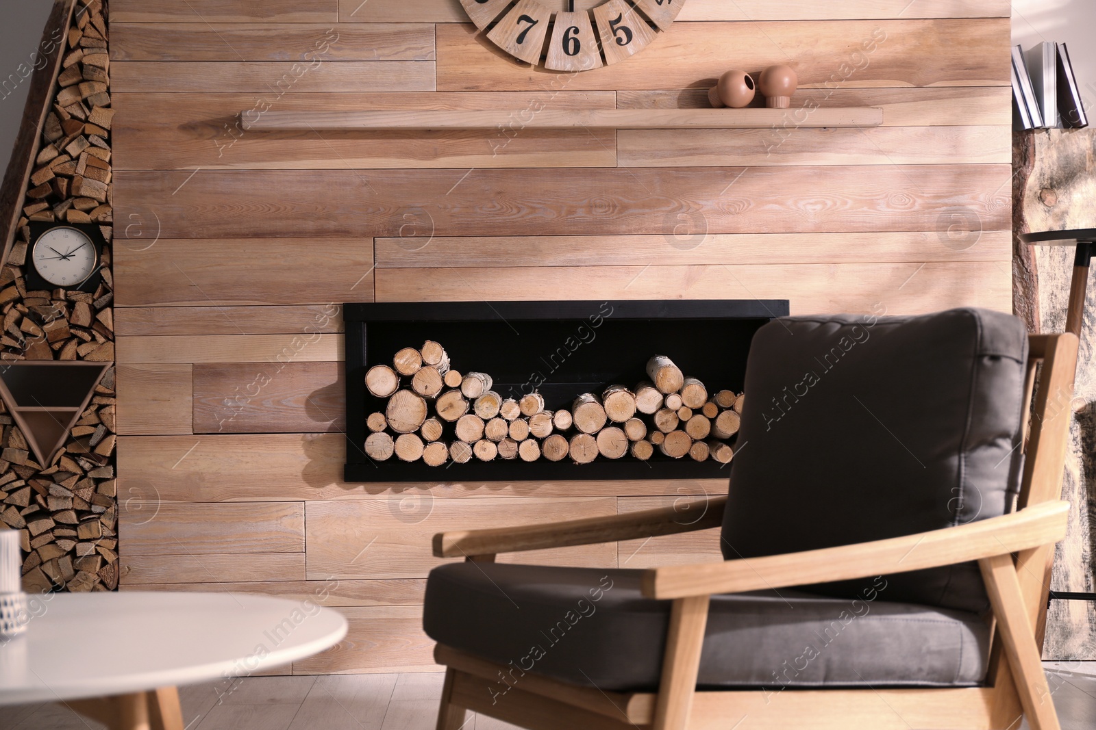 Photo of Decorative fireplace with stacked wood in cozy living room interior