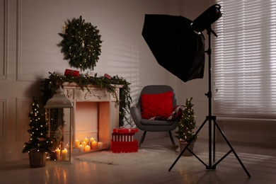 Photo of Beautiful Christmas themed photo zone with professional equipment and fireplace