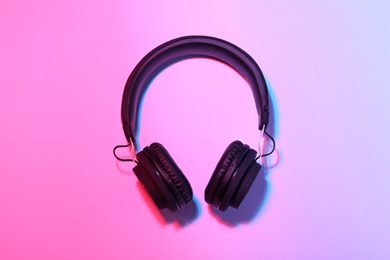 Photo of Stylish headphones on color background, top view