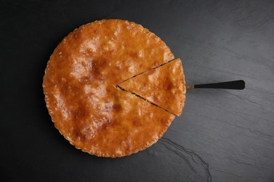 Delicious pie with meat on black table, top view