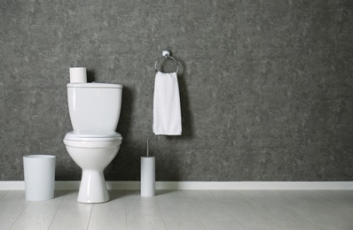 Photo of Simple bathroom interior with new toilet bowl near grey wall. Space for text