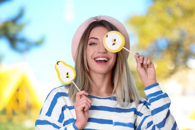 Young happy woman with sweet candies outdoors