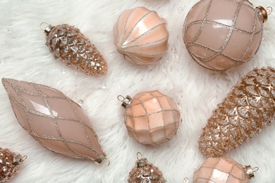Photo of Collection of beautiful Christmas tree baubles on white faux fur, flat lay