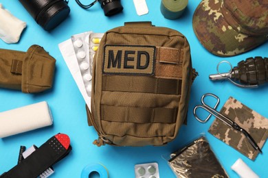 Photo of Military first aid kit and equipment on light blue background, flat lay