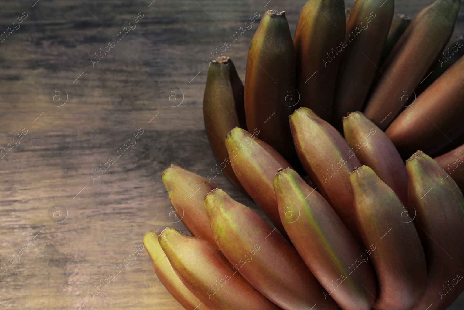 Photo of Tasty purple bananas on wooden table, top view. Space for text