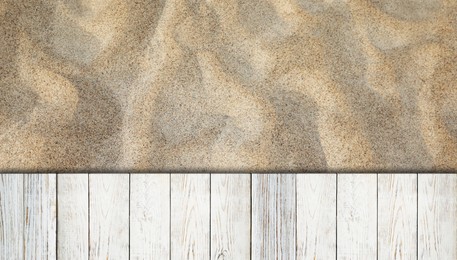 Image of Sand and white wooden planks outdoors, top view. Banner design
