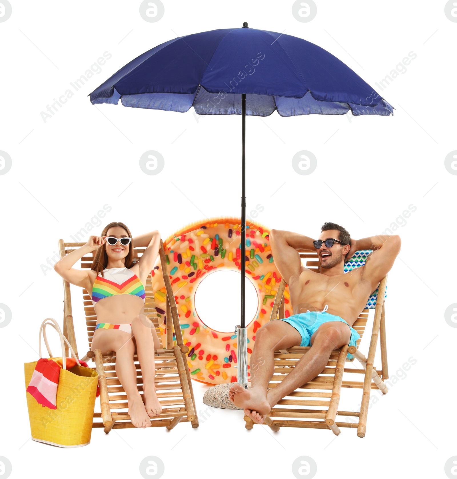 Photo of Young couple with beach accessories on sun loungers against white background