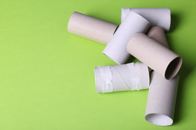 Photo of Empty toilet paper rolls and space for text on color background