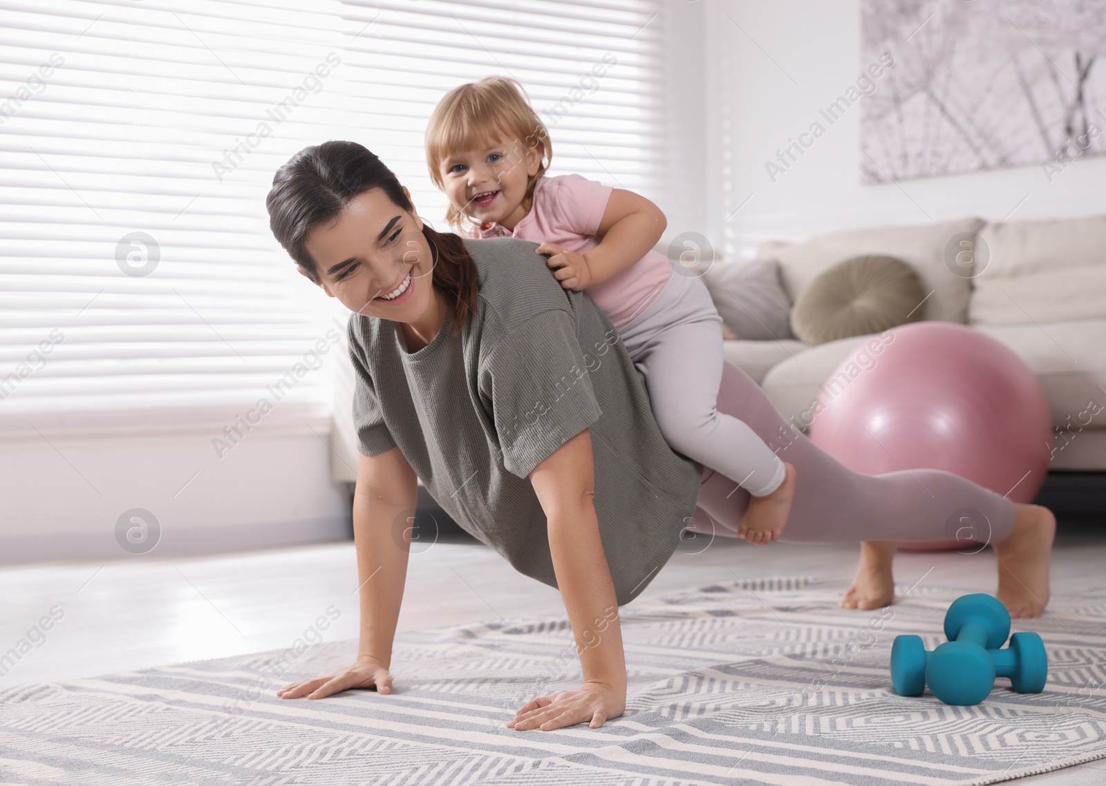 Photo of Mother doing exercise with her daughter at home