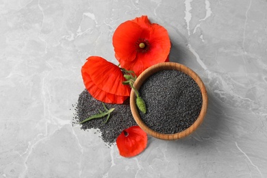Photo of Wooden bowl of poppy seeds and flower on grey table, flat lay