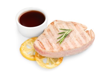 Photo of Delicious tuna steak with sauce, lemon and rosemary isolated on white