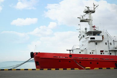 Modern red and white ship moored in sea port