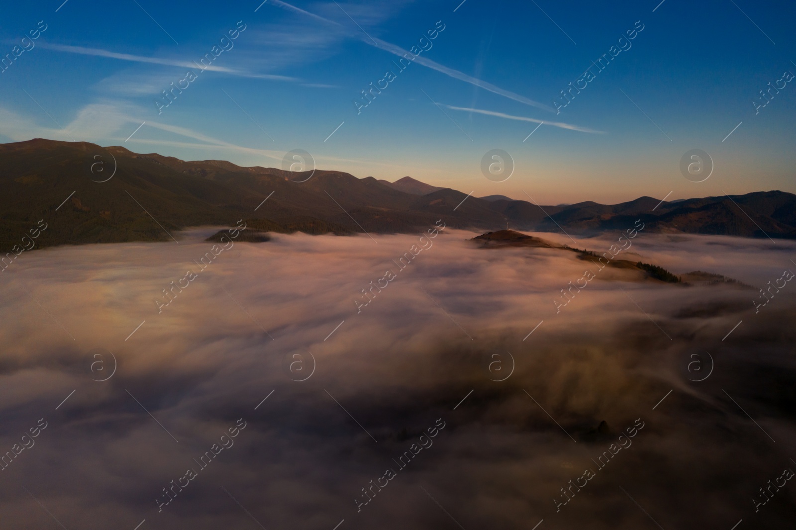 Image of Aerial view of beautiful mountains covered with fluffy clouds. Drone photography