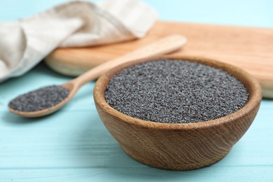 Photo of Poppy seeds in bowl on wooden table